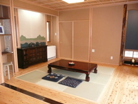 居間の畳は琉球畳敷。三枚引きとを開けると中廊下と一続きの間となります。