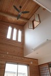 吹き抜けの勾配天井に大きな杉の梁を使用して重量感を出しました。
天井と壁板には無垢の杉板を用いました。玄関側にも吹き抜けを設け　空気の流れをスムーズにしています。